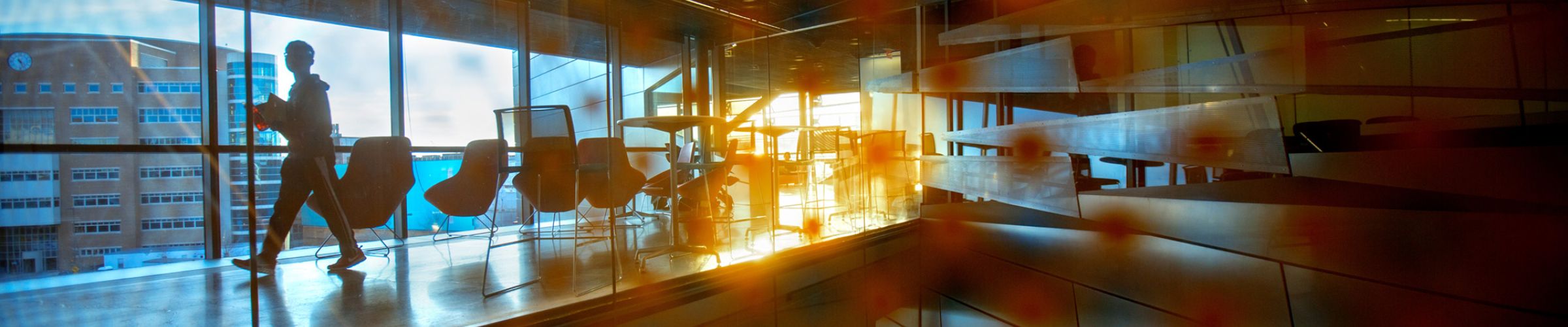 A color photo of the interior of Gates Hall with shadows and a silhouette