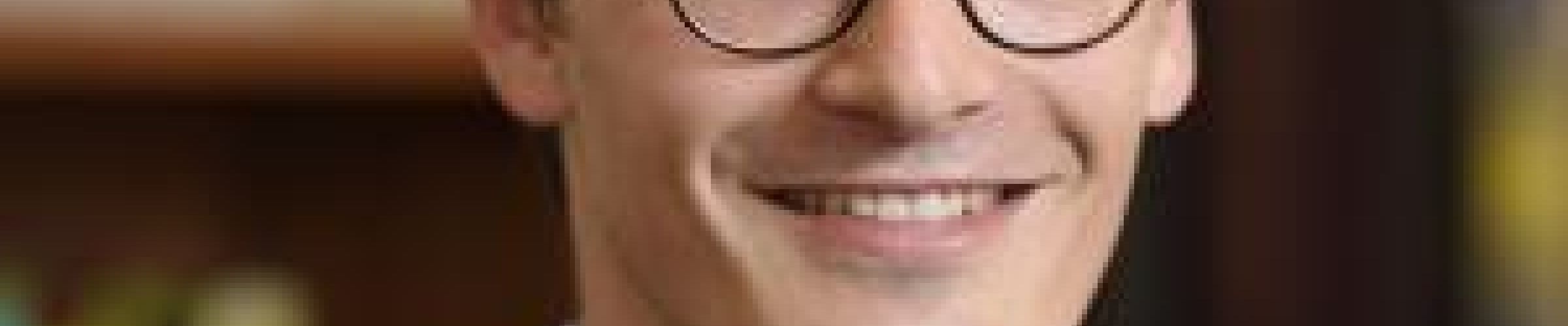 A color photo of a man smiling for a photo
