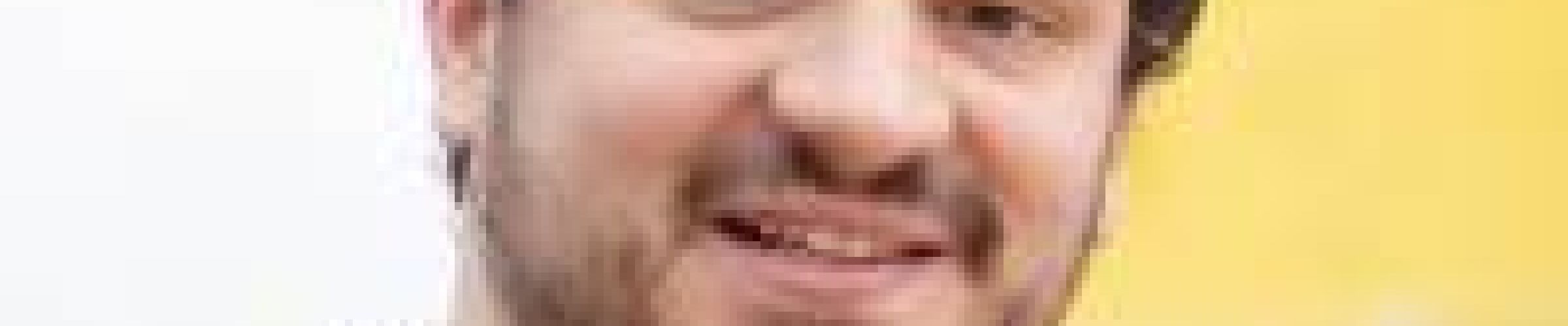A color photo of a man smiling for a photo