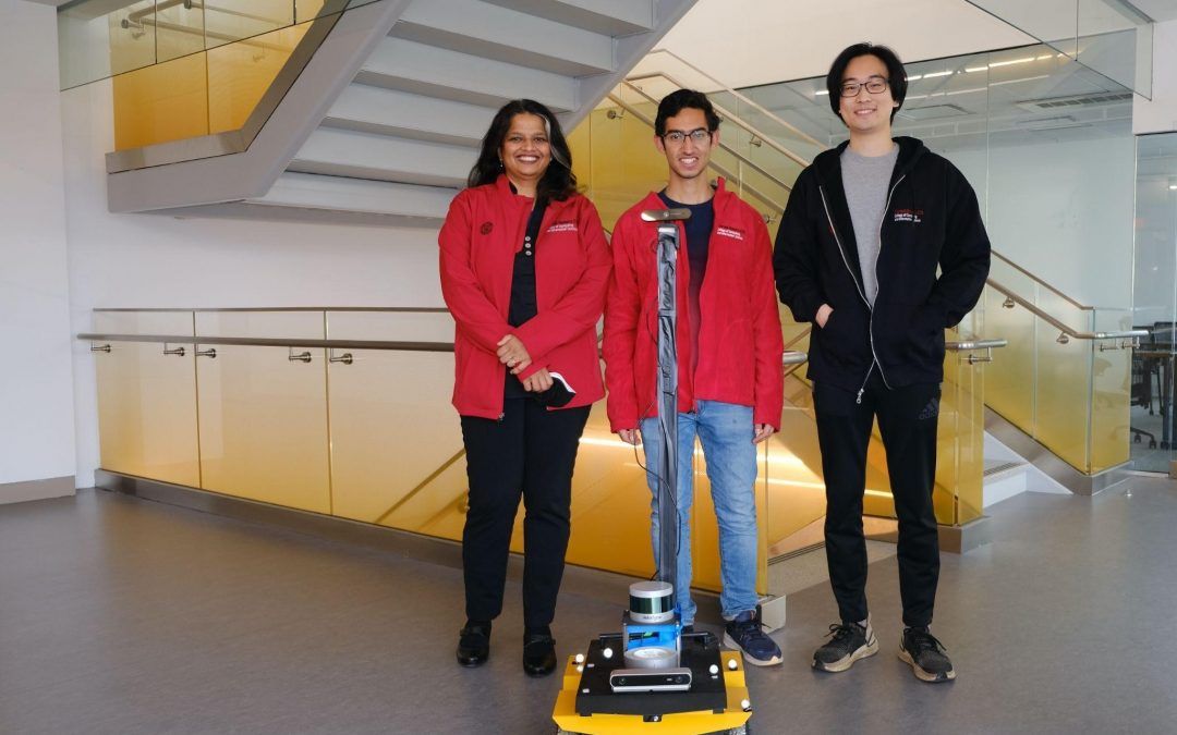 Researchers standing with robot