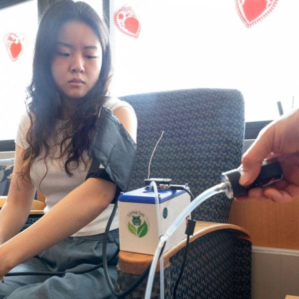A color photo by Ryan Young/Cornell University Adrienne Yoon ’25 demonstrates the use of the manual blood pressure cuff and all-in-one device at Cayuga Medical Center.