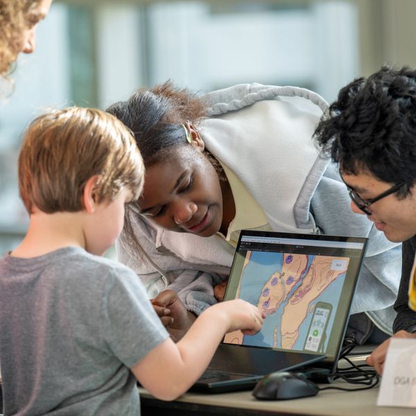 A color photo showing a child playing a game on a computer at BOOM 2025