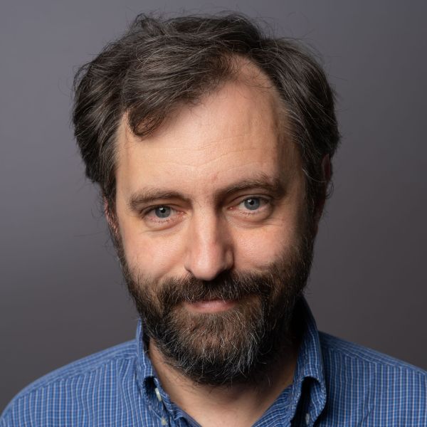 A color photo of a man smiling for a photo