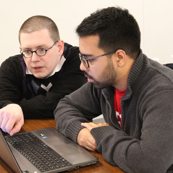 professor helping a student at a computer