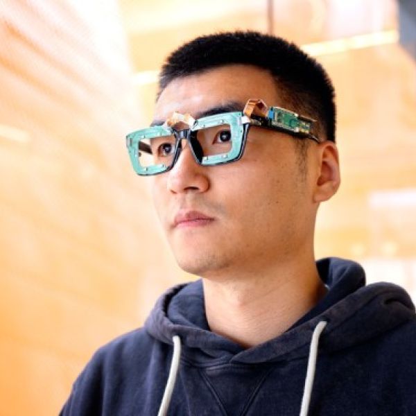 A color photo showing a man wearing smart glasses