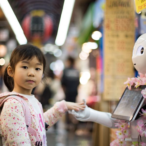 little girl holding hand of robot