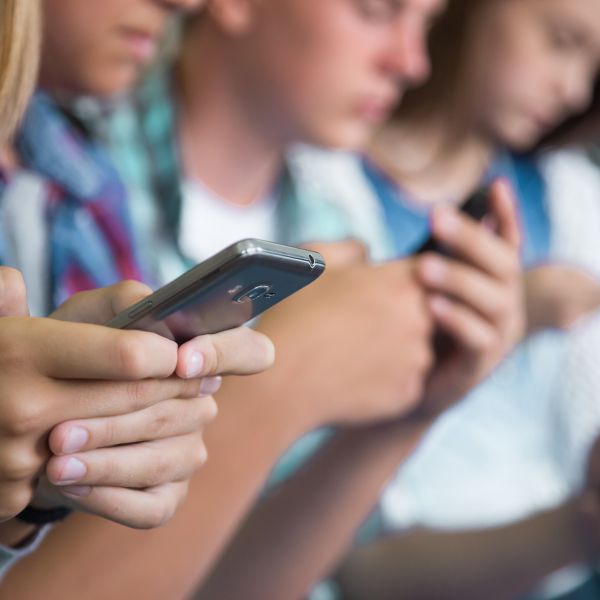 A color photo showing young people using their cell phones