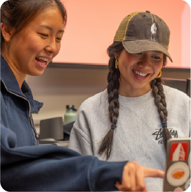 A color photo showing 2 students talking