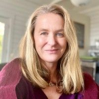 A color photo of a woman smiling for a photo