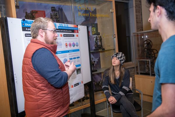 Caption: Michael Sack (left), a doctoral student in the field of information science, explains his team’s project called Enact, a platform to empower environmental literacy & collective action to tackle climate change. Photos by Rachel Philipson