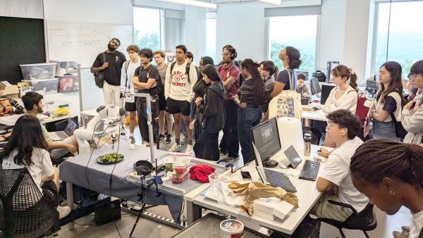 A color photo showing students gathered in a lab for a discussion