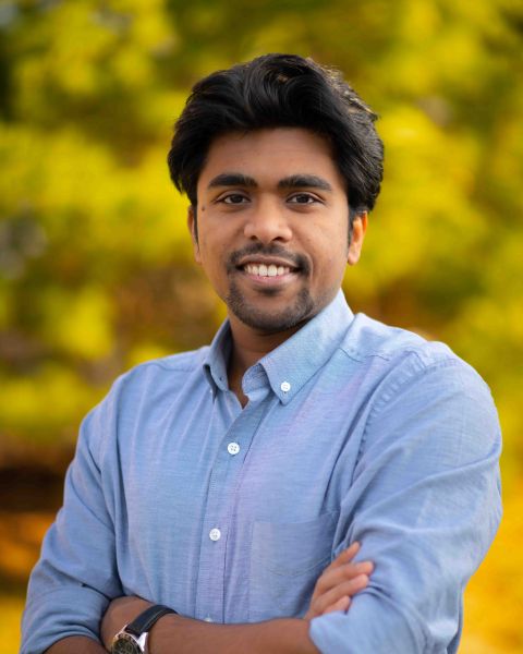 A color photo of a man smiling for a photo