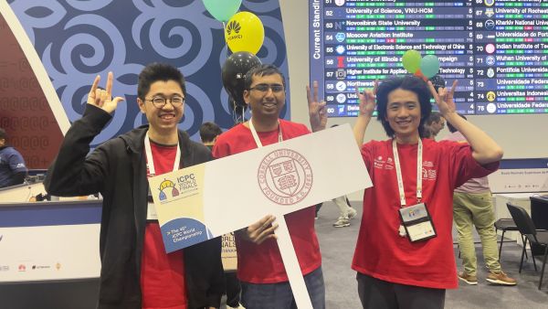 A color photo showing 3 men smiling for a photo at the ICPC World Finals