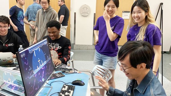 A color photo showing students laughing at the GDIAC showcase