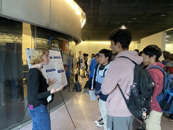 A color photo of woman presenting research to others