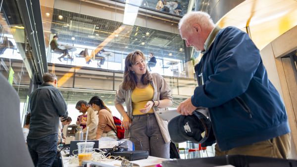 Dylan Van Bramer ’25 (center) assists a community member at last year’s Bowers CIS Earth Day Repair Fair in Gates Hall. (photo by Noël Heaney)