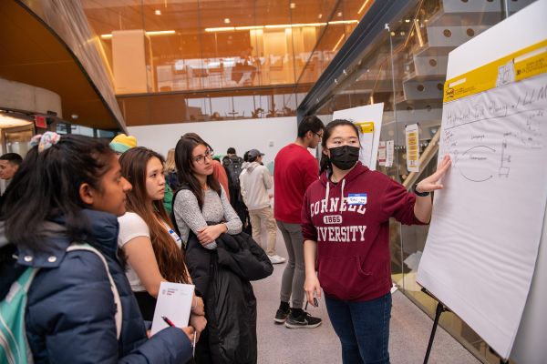 A color photo of someone presenting research to a crowd