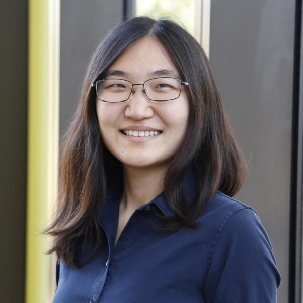 A color photo of a woman smiling for a photo