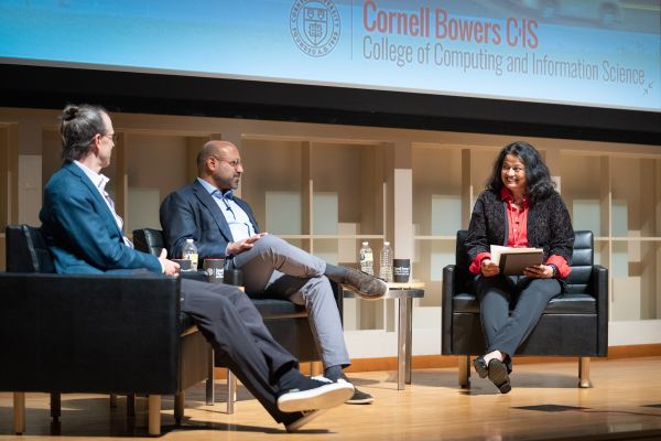 three speakers on stage in chairs talking