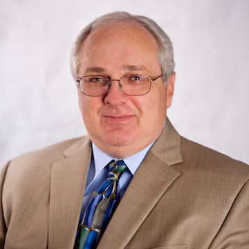 A color photo of a man smiling for a photo