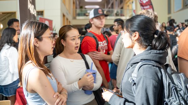 A color photo showing 3 female students talking