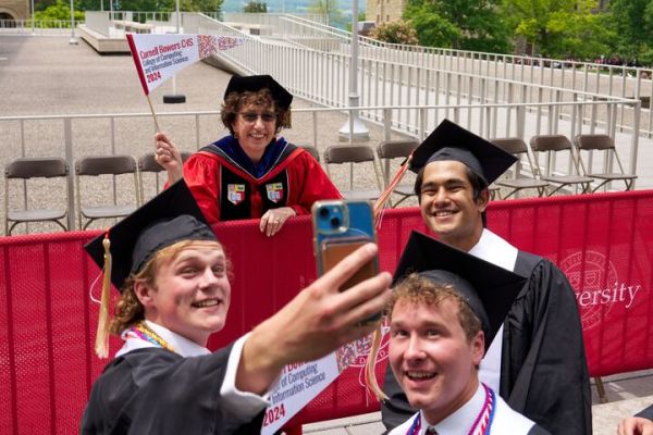 A color photo showing graduates taking a selfie