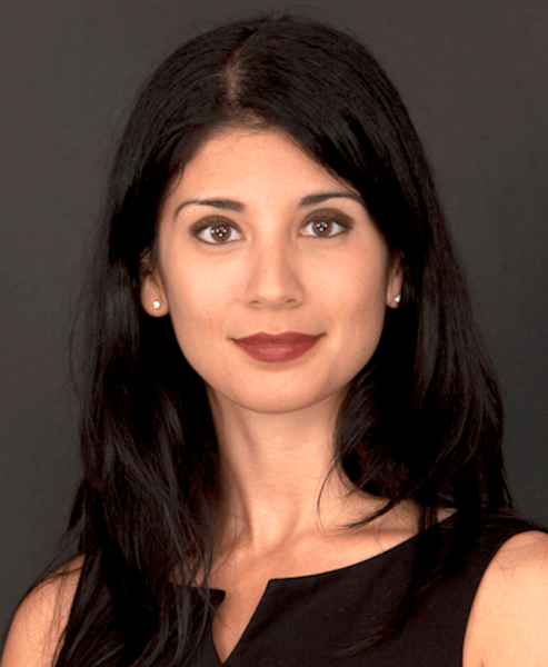 A color photo of a woman smiling for a photo