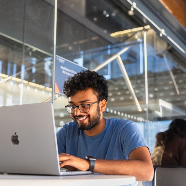 A color photo of a man typing on a computer