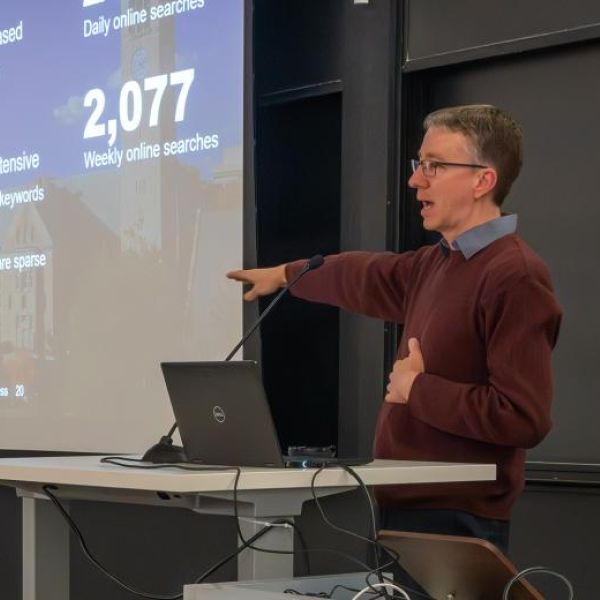 A color photo of a man giving a presentation. by Luke Stewart - Cornell Bowers