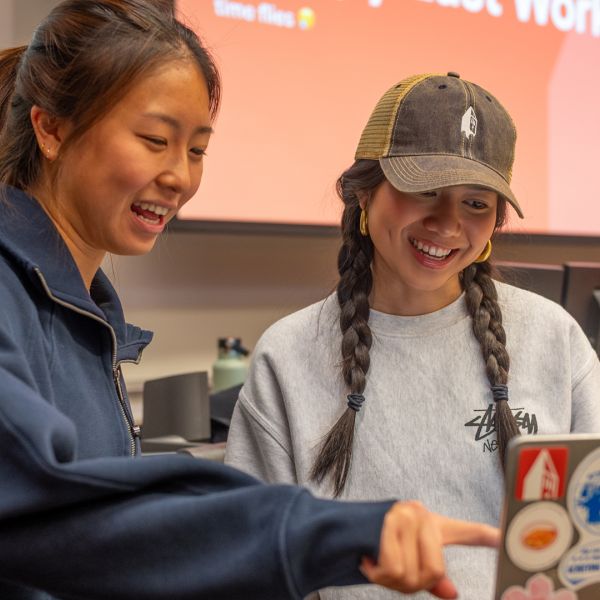 A color photo showing 2 students talking