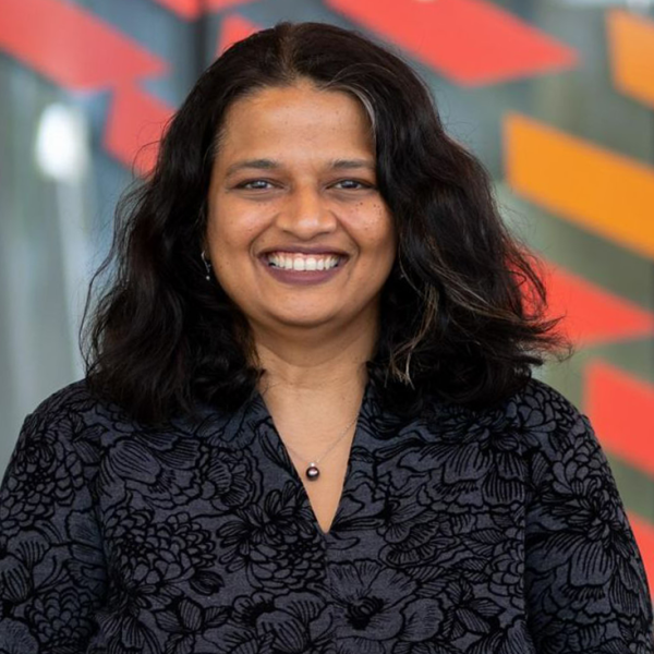 A color photo of a woman smiling for a photo