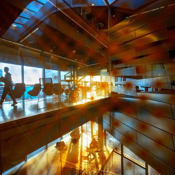 A color photo of the interior of Gates Hall with shadows and a silhouette