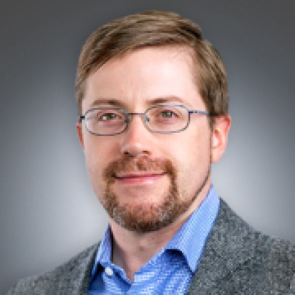 A color photo of a man smiling for a photo