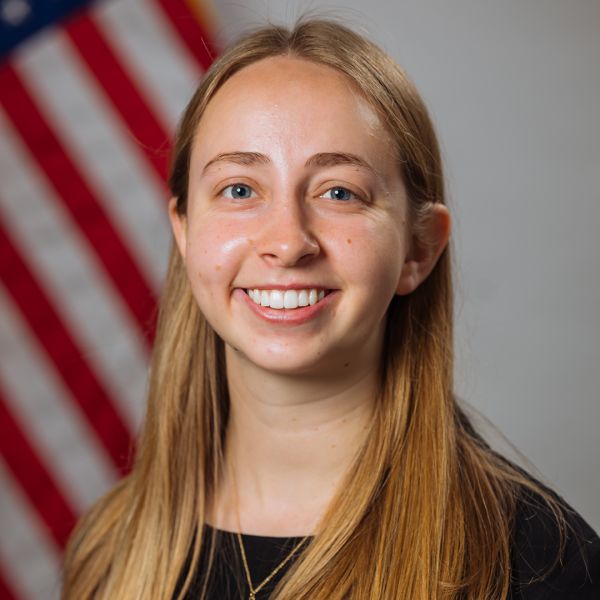 A color photo of a woman smiling for a photo