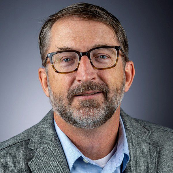 A color photo of a man smiling for a photo