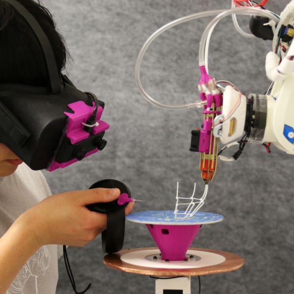 Student interacting with 3D printer wearing augmented reality visor