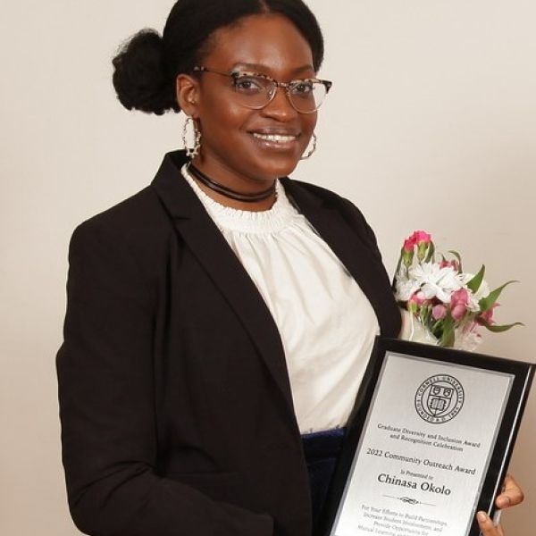 Chinasa T. Okolo holds plaque